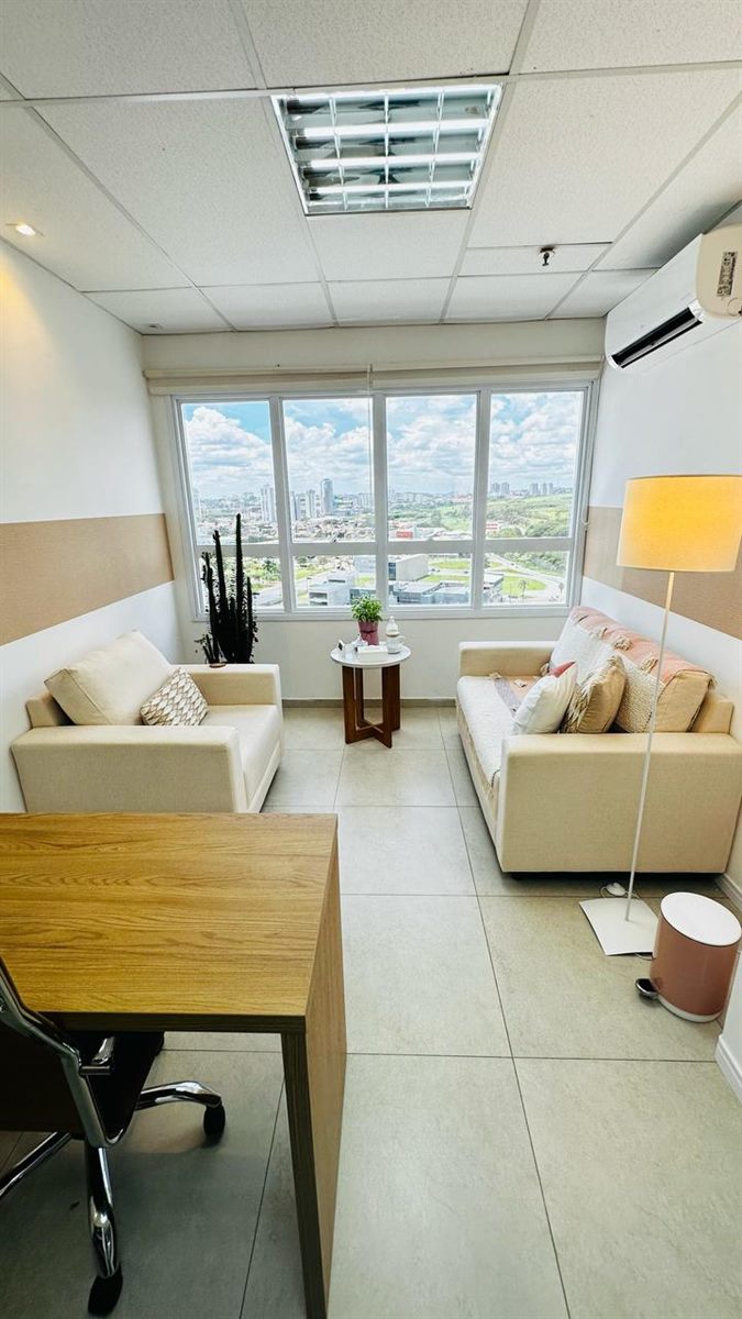 Sala de atendimento com poltronas e vista para a cidade